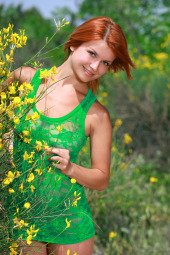 Exciting busty redhead in green summer dress is nude in the field